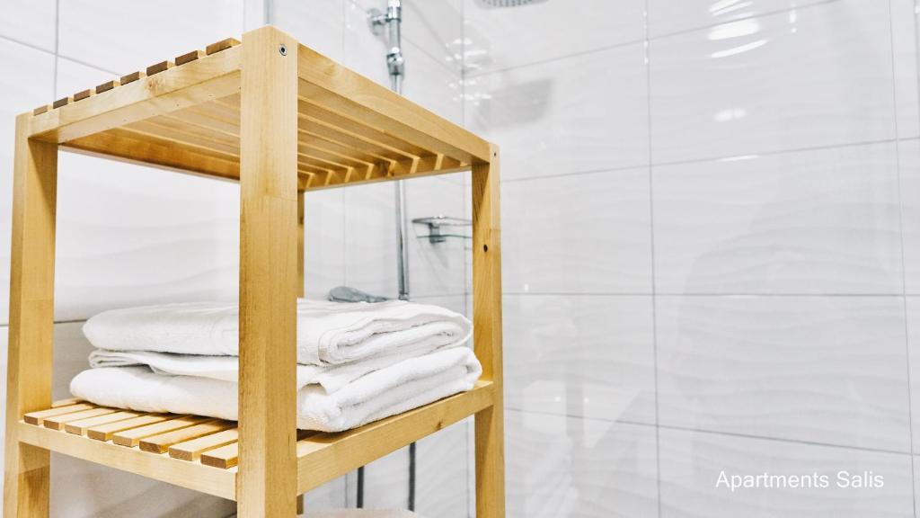 a towel rack in a bathroom with white towels at Salis Apartments in Vrsi