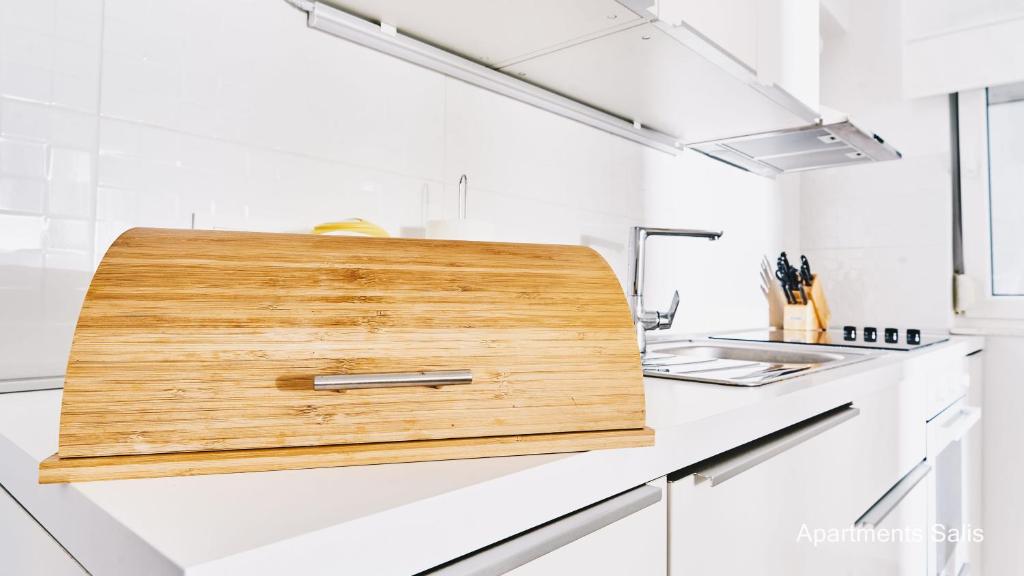 a kitchen with a wooden cutting board on the counter at Salis Apartments in Vrsi