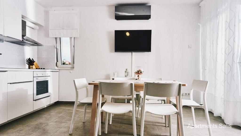 a dining room with a table and chairs in a kitchen at Salis Apartments in Vrsi