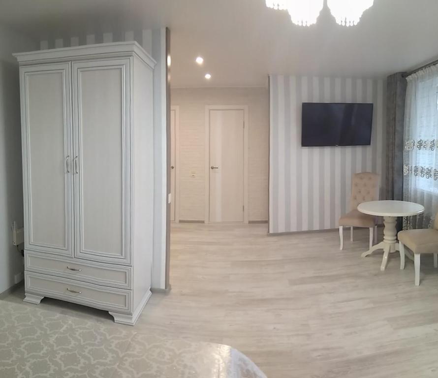 a living room with a white cabinet and a table at Apartment IriS in Baranavichy