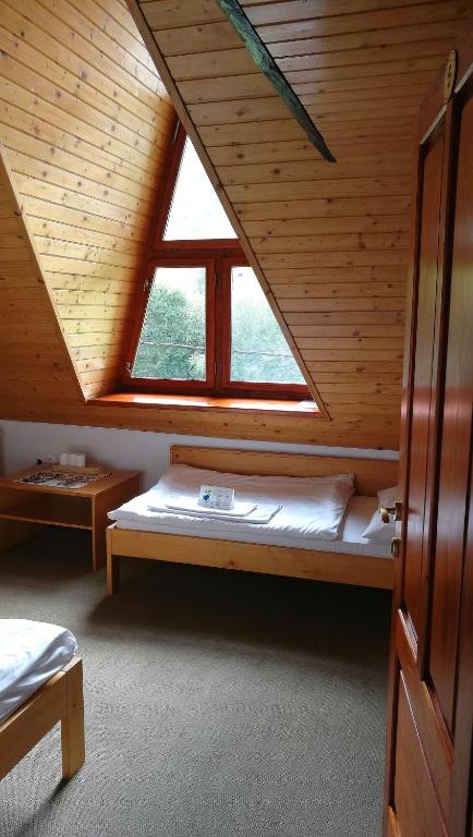 A bed or beds in a room at Penzión Manín