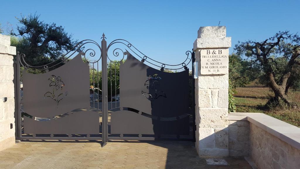 une porte noire avec un panneau devant elle dans l'établissement Trulli dell'aia, à Alberobello