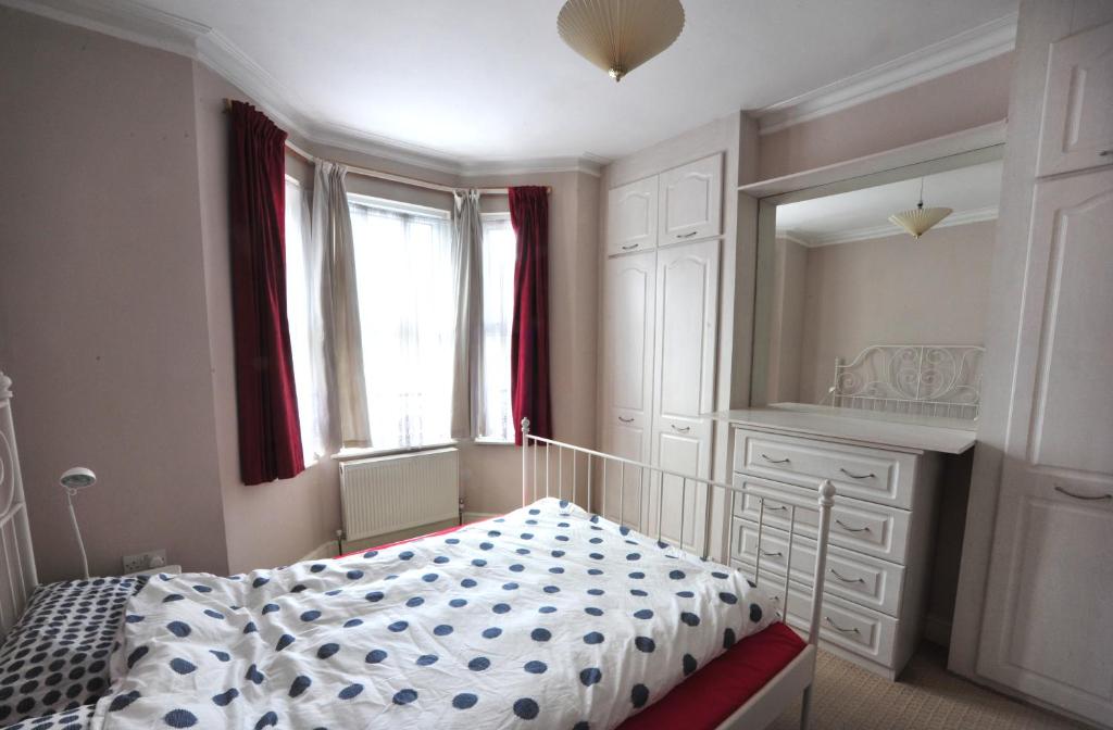 a bedroom with a bed and a dresser and a mirror at East End London Garden Flat in London