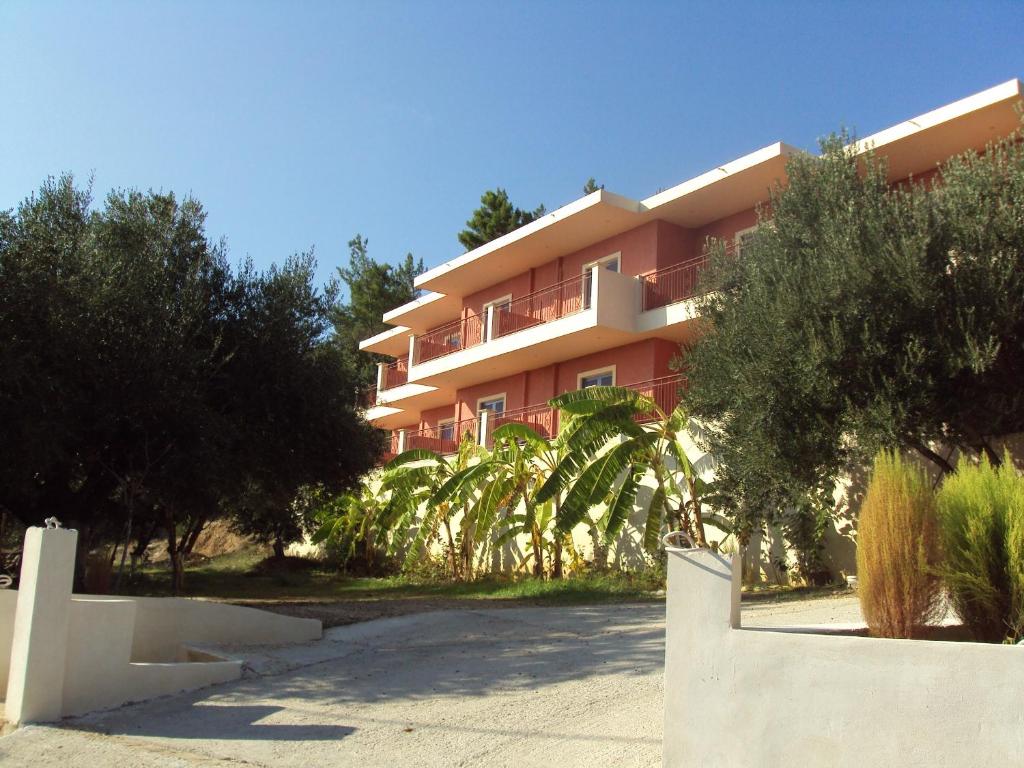 露哈塔的住宿－Anna Studios，一座红色的建筑,前面有棕榈树
