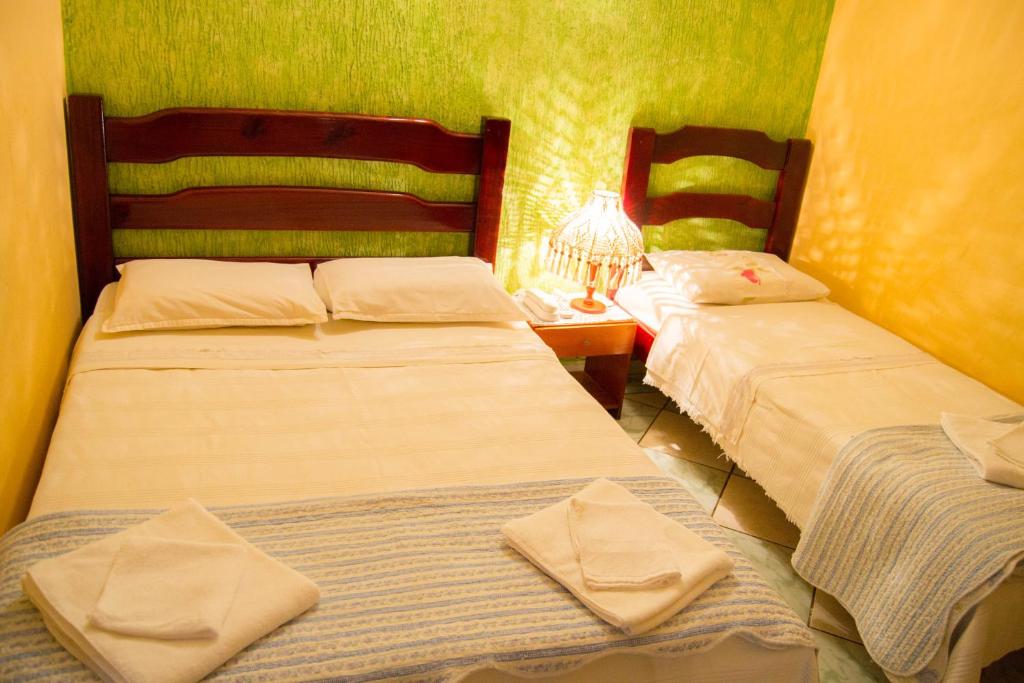 dos camas sentadas una al lado de la otra en una habitación en Hotel & Restaurante Guarania, en Ciudad del Este