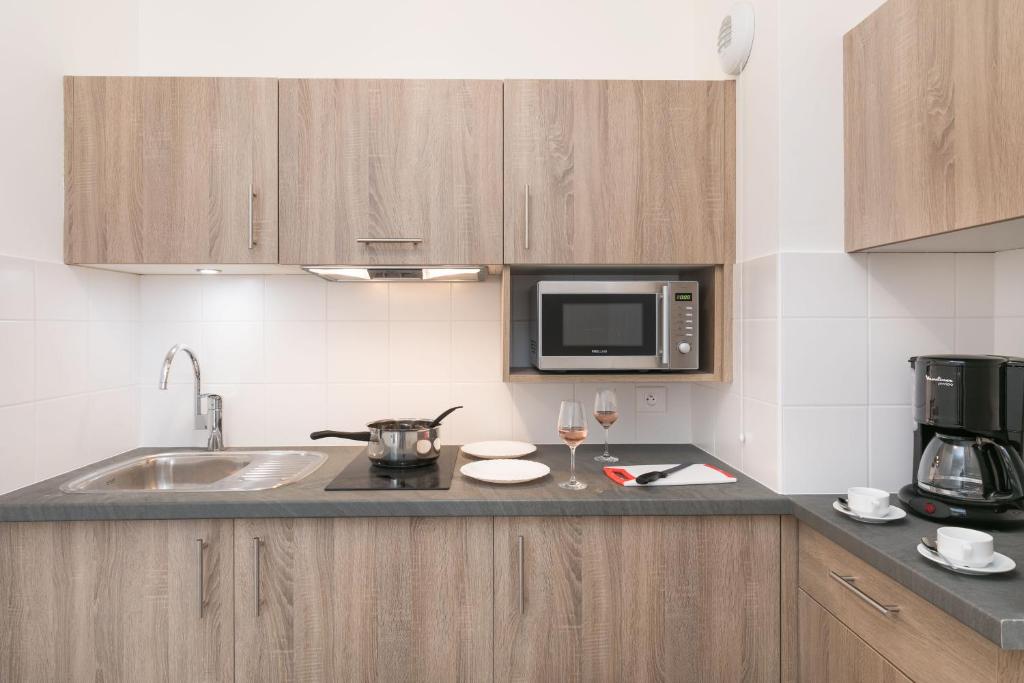 a kitchen with a sink and a microwave at Villa Médicis Trouville-sur-mer in Trouville-sur-Mer