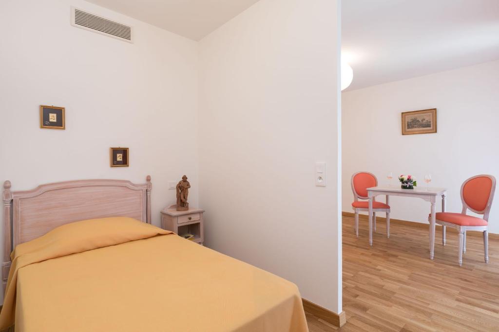 a bedroom with a bed and a table and chairs at Villa Médicis Trouville-sur-mer in Trouville-sur-Mer