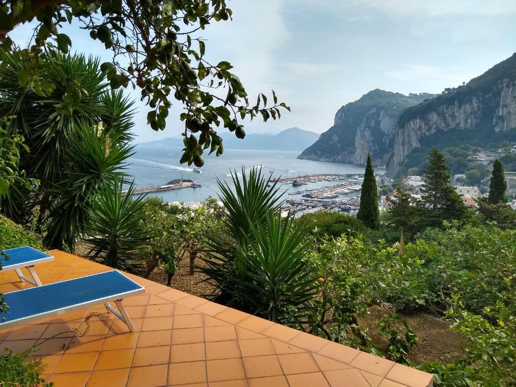 a blue bench sitting on a patio overlooking a beach at Depandance Casa Paolina in Capri