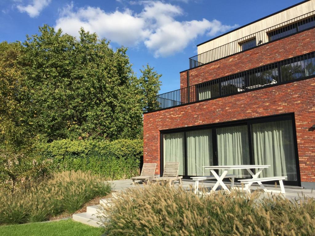 Un edificio de ladrillo con una mesa de picnic delante. en BeHome Dilbeek, en Dilbeek