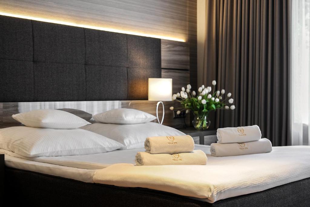 a bedroom with a large bed with white pillows at Hotel Villa Eva in Gdańsk
