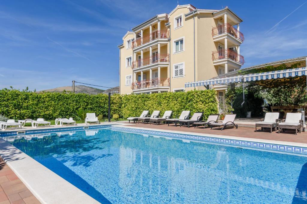 a swimming pool in front of a building at Apartment Mary in Trogir