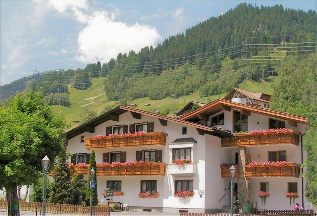 een wit gebouw met bloembakken op de ramen bij Haus Fallesin in Sankt Anton am Arlberg