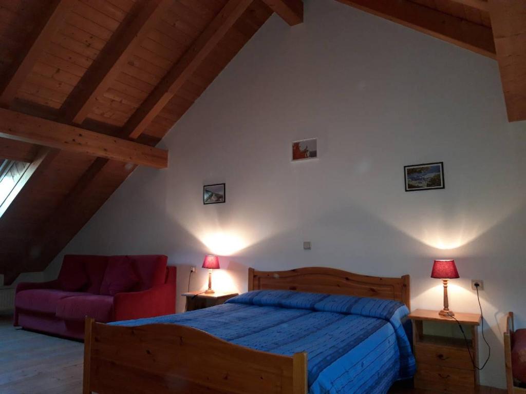 um quarto com uma cama e um sofá vermelho em Residenze Sonnenschein Casa Rossa em Villabassa