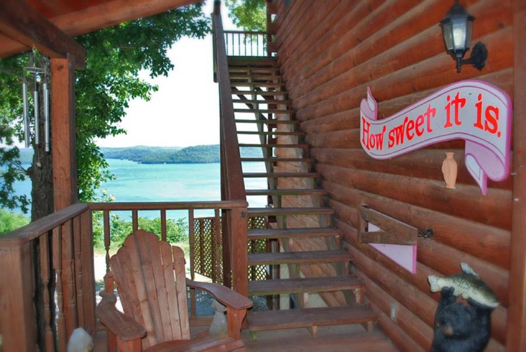 a wooden cabin with a staircase and a sign on it at Sugar Ridge Resort in Eureka Springs