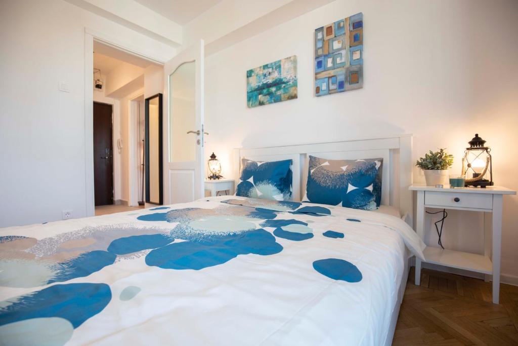 1 dormitorio con 1 cama grande de color azul y blanco en Victoria Avenue Apartment en Bucarest