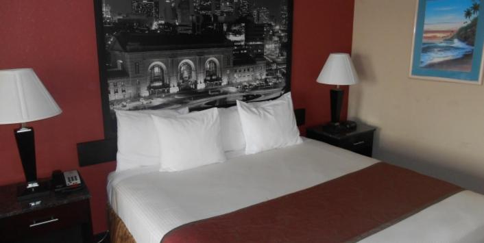 a bedroom with a bed with two lamps and a picture on the wall at AmeriStay Inn St Joseph in Saint Joseph