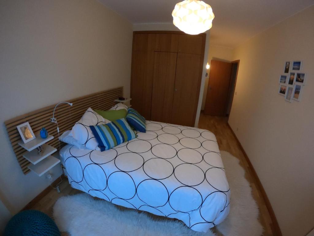 sypialnia z dużym łóżkiem z niebieskimi poduszkami w obiekcie Sea & City w mieście Leça da Palmeira