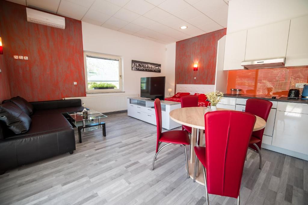 a kitchen and dining room with a table and red chairs at Apartment Lucija-Terme Šmarješke Toplice in Smarjeske Toplice