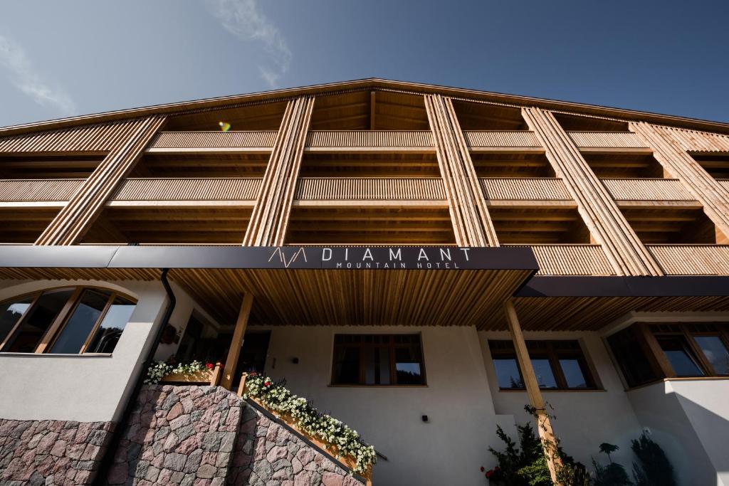 a building with a sign on the front of it at Hotel Diamant in San Cassiano