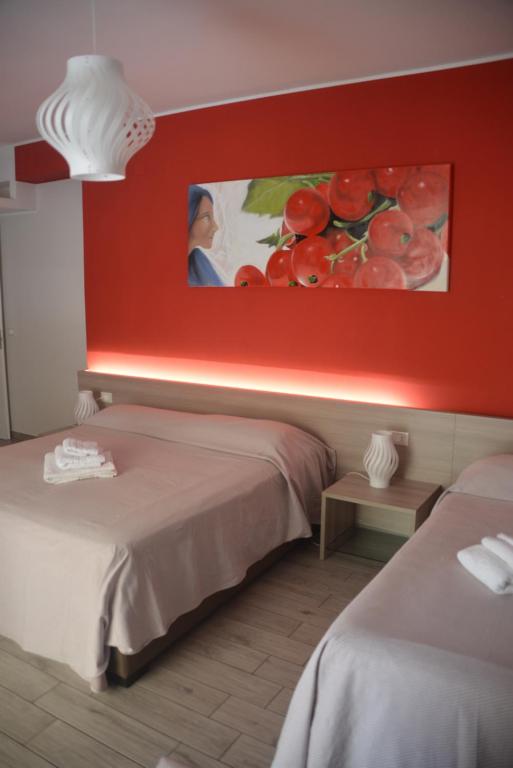 a hotel room with two beds and a painting of tomatoes at B&B Il Giardino Diamante in Diamante