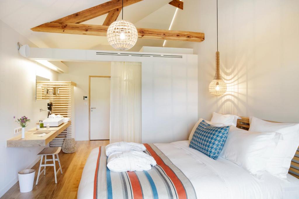 - une chambre blanche avec un lit et un bureau dans l'établissement Hôtel & Restaurant Le Pré, à Durtol