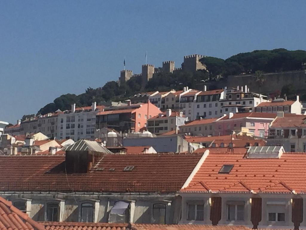 a city with red roofs and a castle on a hill at Apartment Baixa/Chiado view Castle in Lisbon