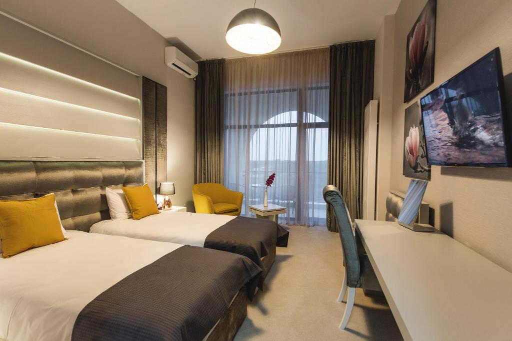 Habitación de hotel con 2 camas y TV de pantalla plana. en Hotel Edma en Alexandria