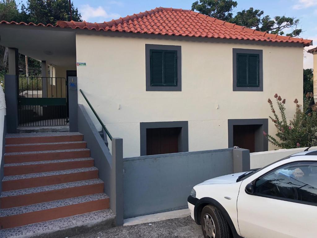 een witte auto geparkeerd voor een huis bij Casa da Igreja in Santana