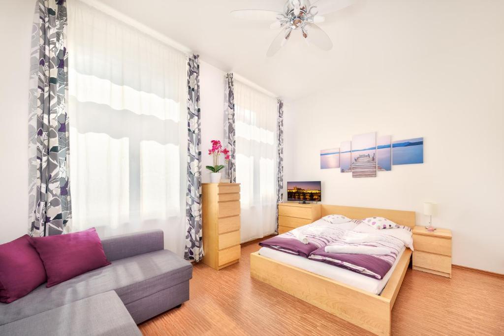- une chambre avec un lit et un canapé dans l'établissement Paradise Apartment, à Prague