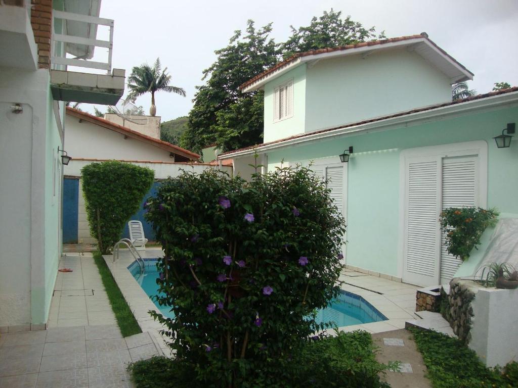 a house with a swimming pool in a yard at Kitnets & Flats in Ubatuba