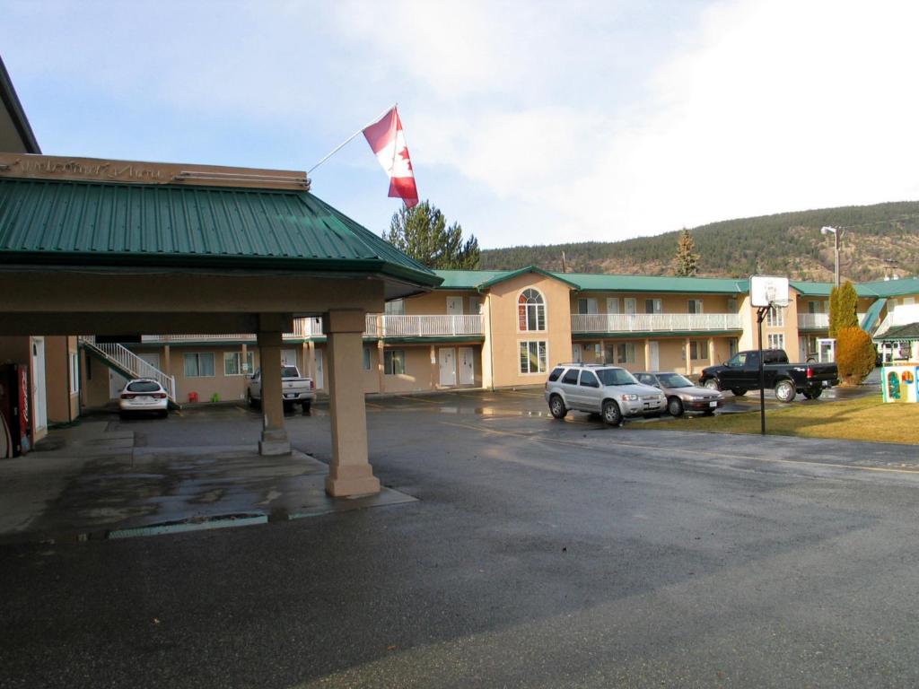 un edificio con una bandera canadiense encima en Intown Inn & Suites en Merritt