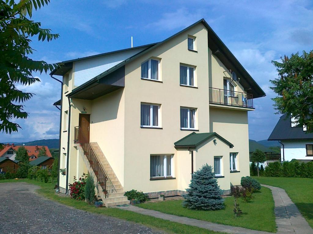 a large white house with a christmas tree in front of it at Nad Bieszczadzkim Morzem in Polańczyk