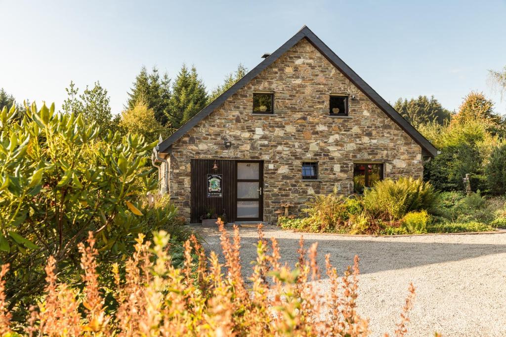 a stone barn with a door in a garden at La Belle du Bayehon in Malmedy