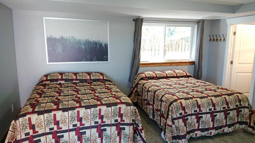 a bedroom with two beds and a window at Caribou Gem in Bancroft