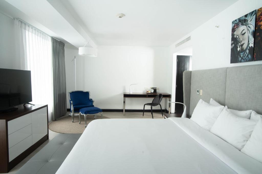 una camera con un grande letto bianco e una scrivania di Radisson Hotel Decapolis Miraflores a Lima