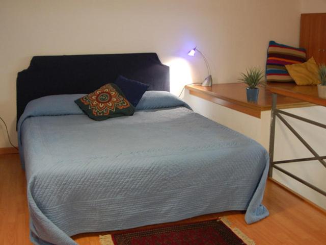 ein Schlafzimmer mit einem Bett mit einem Tisch und einer Lampe in der Unterkunft MiCasaTuCasa in Neapel