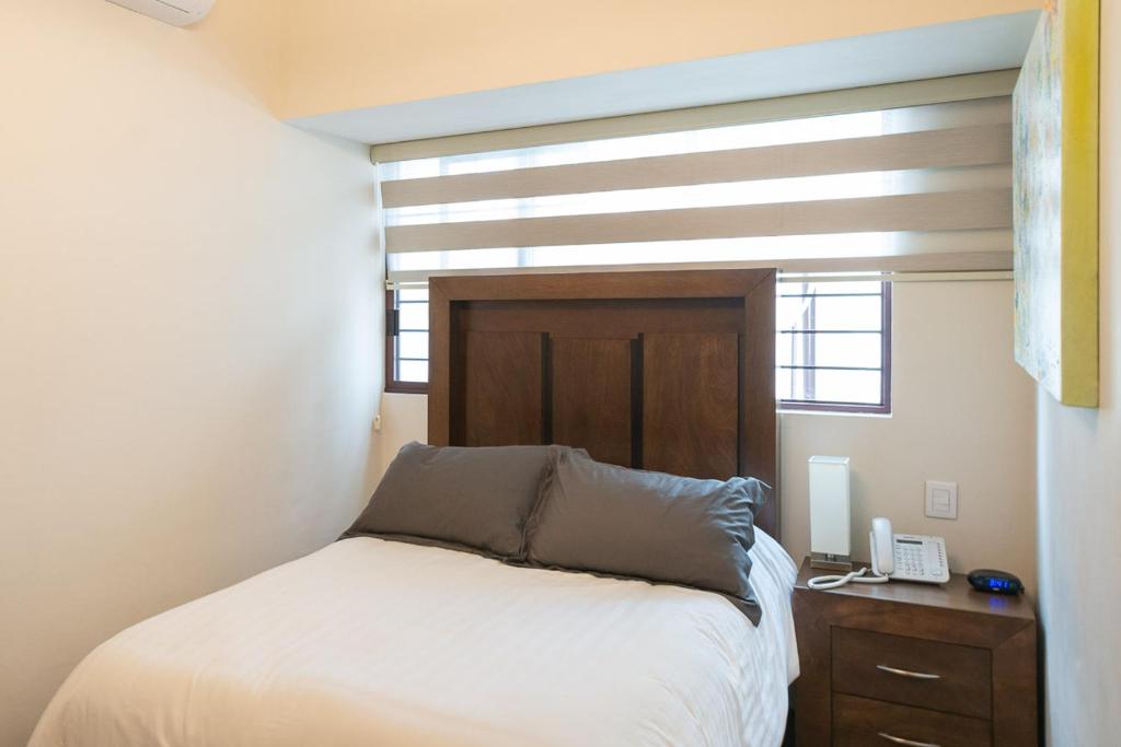 um pequeno quarto com uma cama e uma janela em Hotel Posada XR em Córdoba