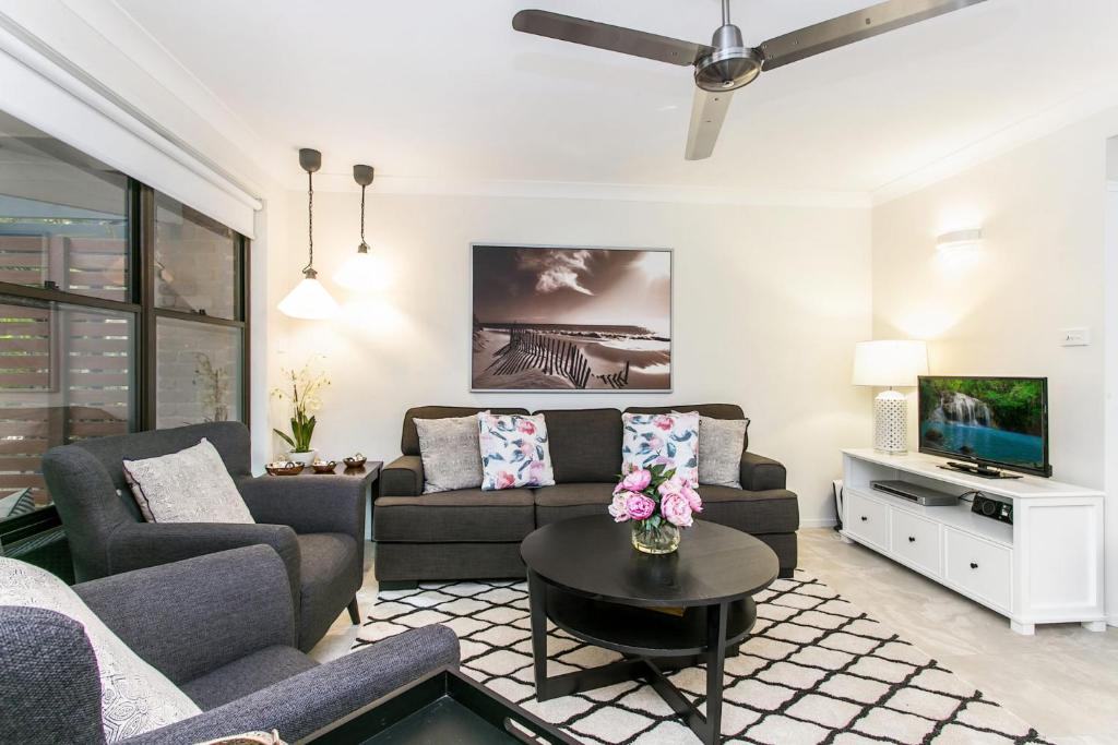 Una sala de estar con un sofá y un televisor. en Calinda Sol 2 @ Clarkes Beach, en Byron Bay