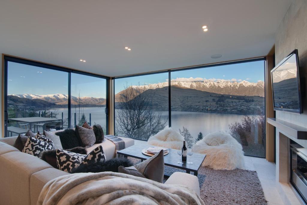 sala de estar con sofá y ventana grande en Panorama House, en Queenstown