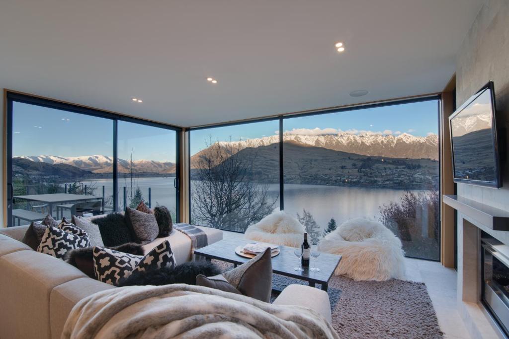 a living room with a couch and a large window at Panorama House by Sotheby's Luxury Rental Homes in Queenstown