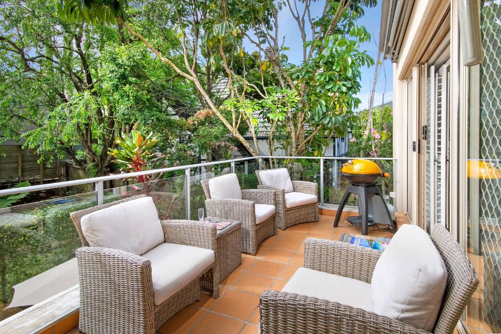 a patio with chairs and a grill on a balcony at Alderly Apartment 11, Little Cove in Noosa Heads