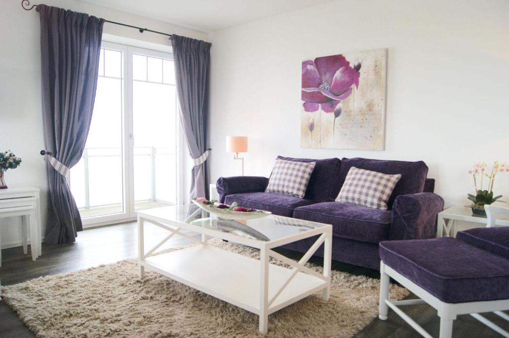 ウィトデュンにある*Strandloge*の紫色のソファとテーブル付きのリビングルーム