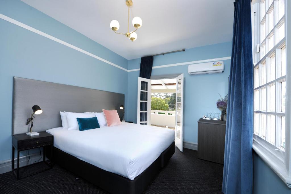a bedroom with a bed and a window at The Stirling Arms Hotel in Perth
