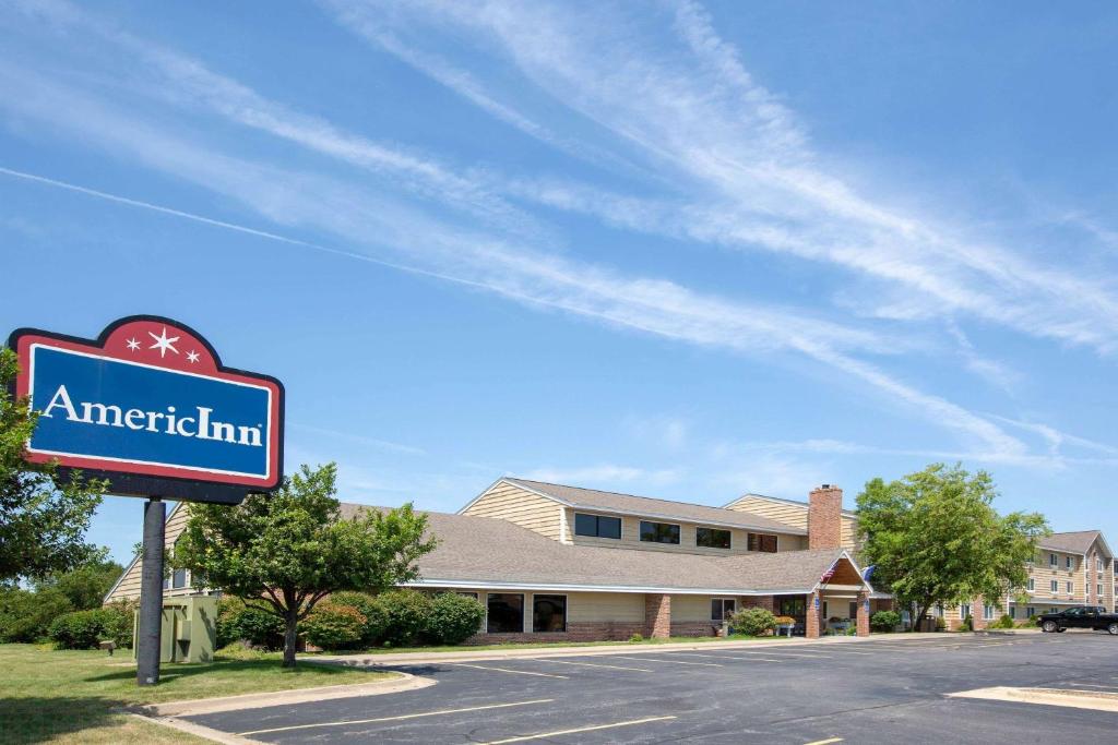 ein Schild für einen amerikanischen Gasthof vor einem Gebäude in der Unterkunft AmericInn by Wyndham Coralville in Coralville