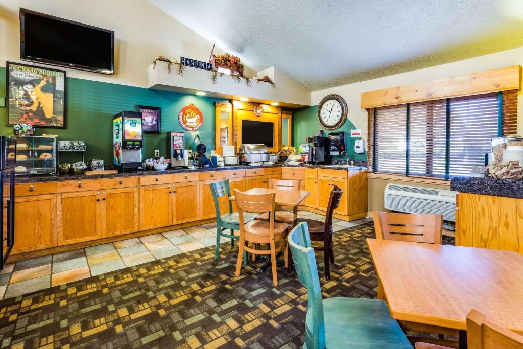a kitchen with wooden cabinets and a table and chairs at AmericInn by Wyndham Hampton in Hampton