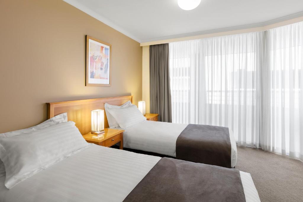 a hotel room with two beds and a window at Nesuto Canberra in Canberra
