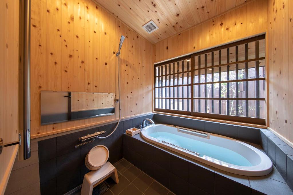 琴平町にあるこんぴら町家 Konpira Machiyaのバスルーム(バスタブ、トイレ付)、窓が備わります。