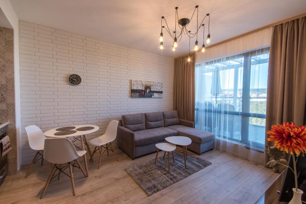 sala de estar con sofá, mesa y sillas en City Apartments Triumph en Varna