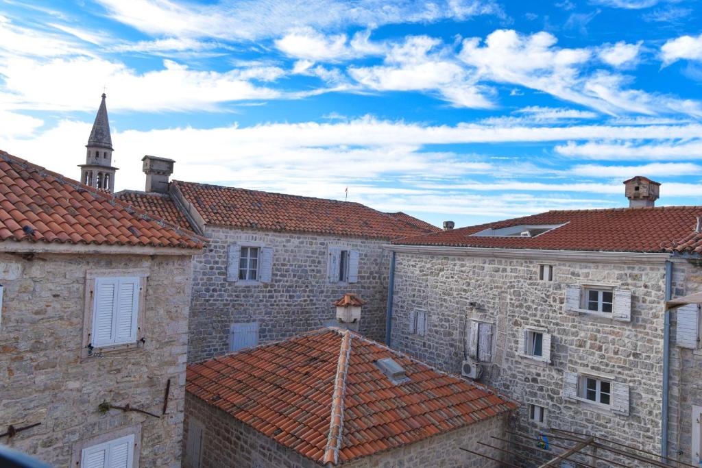 a building with red tile roofs and a church steeple at Comfort Inn Old Town in Budva