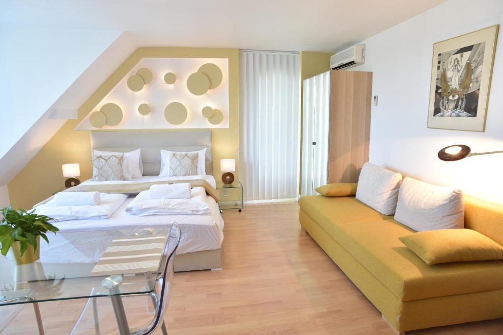 ブダペストにあるHillside Premium Apartmentsのベッドルーム(大型ベッド1台、ソファ付)